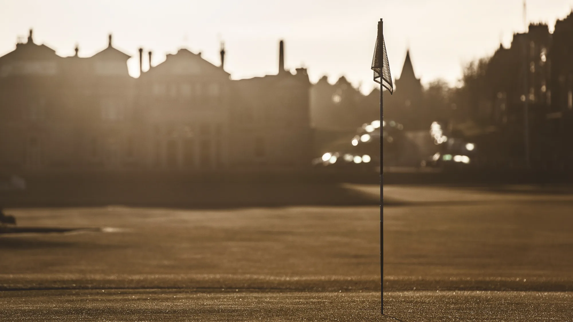 The eighteenth green of the Old Course in evening light, the town behind