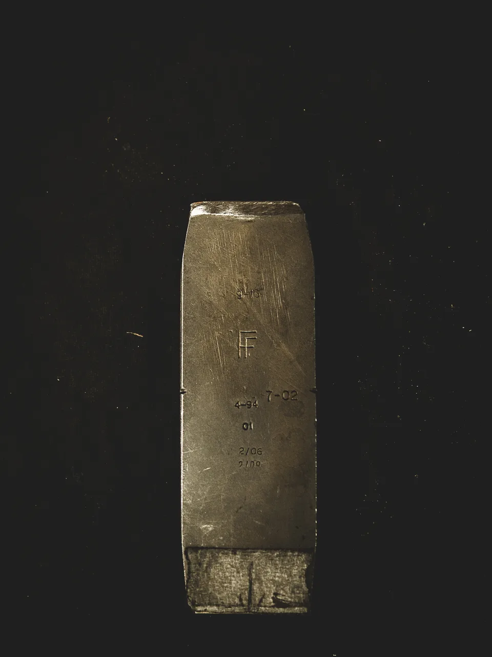 The face of an old forged iron head, stamped with maker’s marks