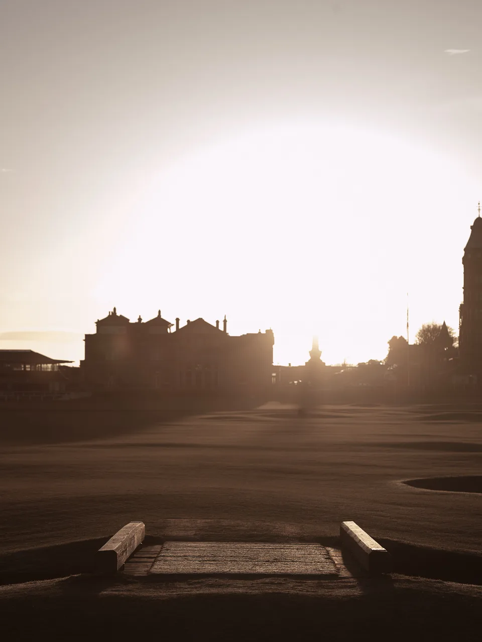 The Old Course at St Andrews at sunset, the town in silhouette beyond